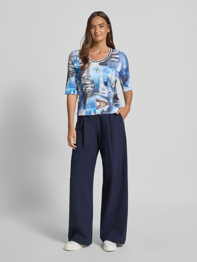 Frauenmodel trägt T-Shirt im Allover-Look mit 3/4-Arm von Marc Cain, Baumwoll-Elasthan-Mix, Regular-Fit, Rundhalsausschnitt, Rückenlänge bei Größe 36: 54 cm, blau gemustert, Ganzkörperansicht von vorne.