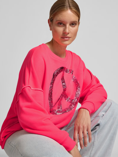 Frauenmodel trägt Oversized Sweatshirt aus Baumwoll-Mix von miss goodlife in Pink mit Pailettenbesatz und Rundhalsausschnitt, Nahaufnahme Oberkörper.
