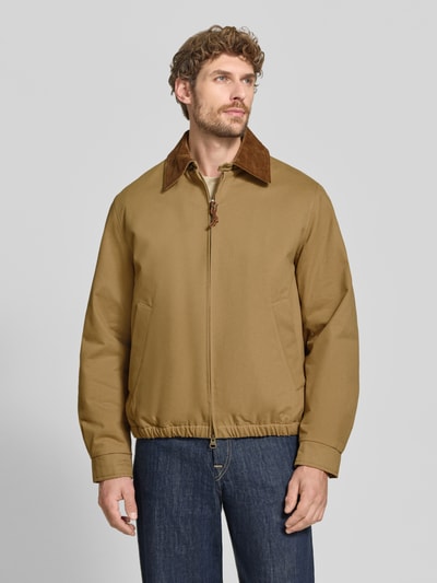 Männermodel trägt Regular Fit Bomberjacke aus reiner Baumwolle Modell 'HARRINGTON' von GANT in Beige mit dunkelbraunem Kragen, Herren Bomberjacke / Blouson, Ganzkörperansicht von vorne.