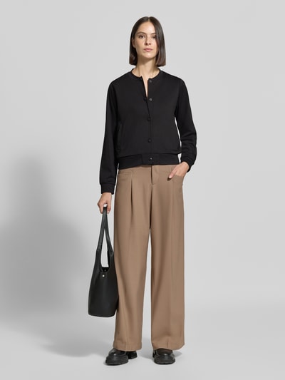 Frauenmodel trägt Regular Fit Sweatjacke mit Viskose-Anteil Modell 'SC-DANIELA 11' von Soyaconcept in Schwarz, kombiniert mit weiter brauner Hose, glatte Oberflächen, Ganzkörperansicht von vorne, Damen Sweatjacke von Soyaconcept.