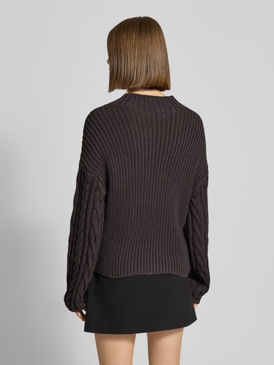 Kobiece modelka nosi Slim Fit Sweter w imitacji dzianiny Model 'Haysa' od Noisy May, mieszanka bawełny, okrągły dekolt, długość tyłu 58 cm, rękawy 67 cm, czarny, faktura prążkowana i wzór warkoczowy, widok całego ciała z tyłu.