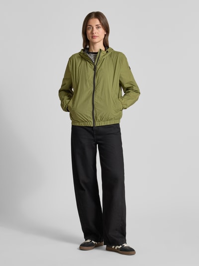 Frauenmodel trägt Regular Fit Jacke mit Kapuze Modell 'Nigle' von Peuterey in Olivgrün, zweiwege-Reißverschluss, Ganzkörperansicht von vorne