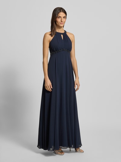 Frauenmodel trägt Regular Fit Abendkleid mit Rückenausschnitt von Jake*s Cocktail, dunkelblau mit Ziersteinbesatz, Ganzkörperansicht von vorne.