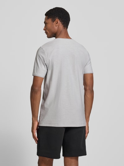 Męski model nosi T-Shirt mit V-Ausschnitt und Rollsaum von MCNEAL, bawełna, krój regular fit, długość tyłu w rozmiarze M: 81 cm, jasnoszary z czarnymi szortami, gładka faktura, widok całej sylwetki z tyłu