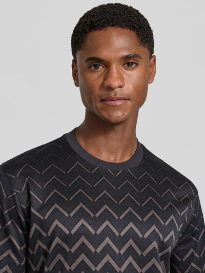 Männermodel trägt T-Shirt mit Rundhalsausschnitt von Emporio Armani, Baumwoll-Lyocell-Mix, gerader Schnitt, Nahaufnahme Oberkörper.