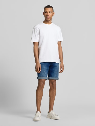 Männermodel trägt Bermudas im 5-Pocket-Design mit Aufschlag von Christian Berg Men aus Baumwoll-Mix mit Stretch-Anteil, Ganzkörperansicht von vorne.