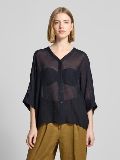 Frauenmodel trägt Relaxed Fit Bluse aus Viskose-Mix mit V-Ausschnitt von Comma, transparentes Material, Knopfleiste, 3/4-Arm, Ganzkörperansicht von vorne.