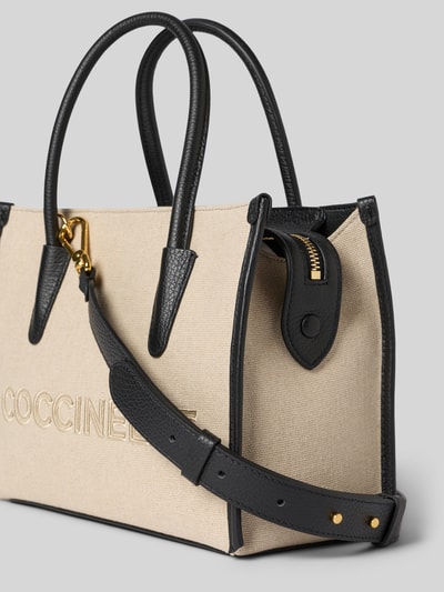 Produktfoto, Handtasche mit Label-Stitching von Coccinelle in Beige und Schwarz, aus Canvas mit Tragehenkel und Schulterriemen, Hauptfach mit Reißverschluss, Maße 27 cm Breite, 20 cm Länge, 13 cm Tiefe, Schulterriemen 105 cm