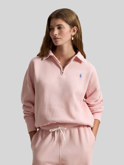 Frauenmodel trägt Sweatshirt mit Label-Stitching von Polo Ralph Lauren in hellem Rosa, Baumwoll-Mix, Polokragen, Nahaufnahme Oberkörper.