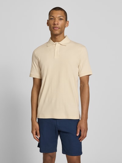 Männermodel trägt Regular Fit Poloshirt reiner Baumwolle Modell 'COLE' von SELECTED HOMME in Beige, strukturierter Jersey, Ganzkörperansicht von vorne.