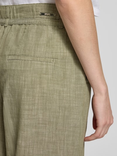 Frauenmodel trägt Wide Fit Stoffhose mit Bügelfalten Modell 'Livia' von Angels aus Reine Baumwolle, grün, Nahaufnahme Hüfte Rückansicht.