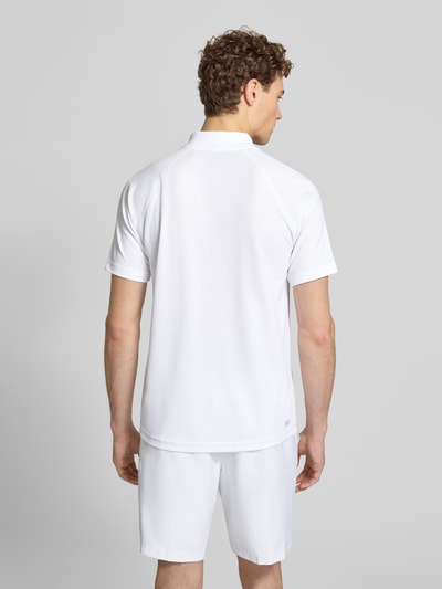 Mężczyzna nosi Regular Fit Sport Poloshirt mit Label Patch od Lacoste Sport, biały piqué, krótki rękaw, gładki, polokrag, widok całej sylwetki z tyłu.