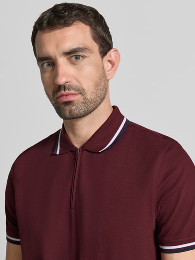 Männermodel trägt Slim Fit Poloshirt mit Kontraststreifen und Reißverschluss von MCNEAL, Baumwoll-Elasthan-Mix, Nahaufnahme Oberkörper.