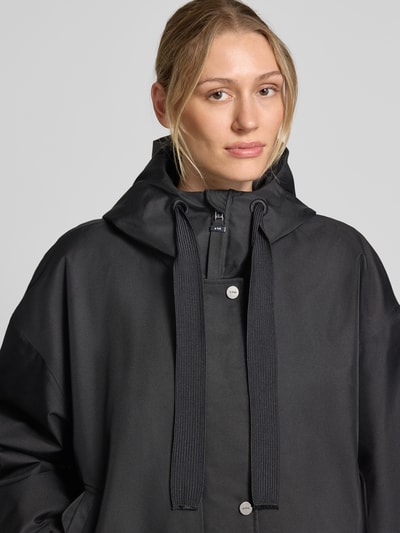 Kobieta modelka nosi czarną kurtkę Regular Fit ze stójką Model 'Rosie' od g-lab, kaptur z tunelem, wpuszczane kieszenie, zbliżenie na górę ciała.