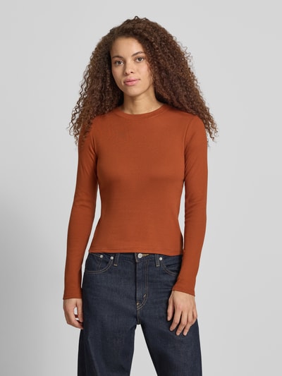 Kobiece model nosi bluzkę z długim rękawem z bawełny w kolorze ceglastym, krój regular fit, model 'EVERYDAY' od Topshop, okrągły dekolt, długość tyłu w rozmiarze S: 53 cm, widok całej sylwetki z przodu