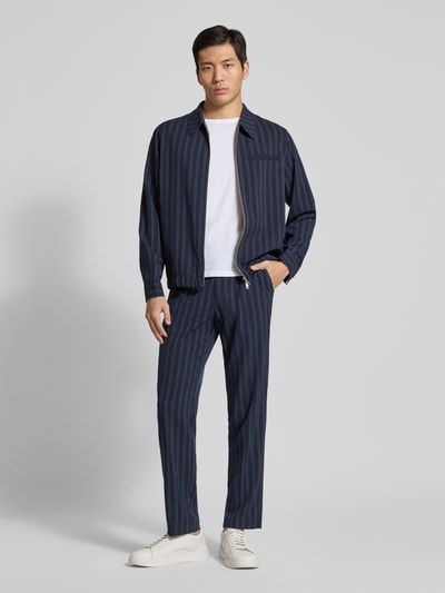 Männermodel trägt Hose mit Streifenmuster von Lindbergh, dunkelblau mit weißen Streifen, Material-Mix, Regular Fit, Ganzkörperansicht von vorne.