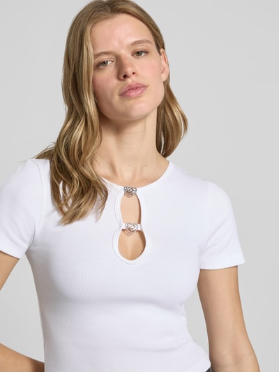 Frauenmodel trägt Slim Fit T-Shirt aus Baumwoll-Mix Modell 'DIHEART_B' von Hugo Blue, Optik: Unifarben, Label-Applikation aus Metall, Rundhals mit Cut-Out, Kurzarm, Materialverarbeitung: Ripp, Nahaufnahme Oberkörper.