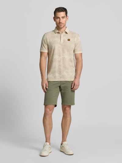 Męski model nosi Slim Fit Poloshirt mit Label-Patch von PME Legend z bawełny, wzór na całej powierzchni, listwa guzikowa, długość tyłu w rozmiarze M 74 cm, całkowity widok z przodu.