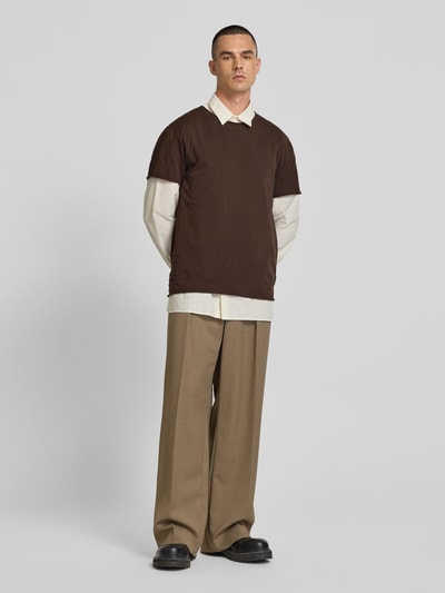 Männermodel trägt T-Shirt mit Rundhalsausschnitt von Filippa K aus brauner Baumwolle im Regular Fit, Ganzkörperansicht von vorne.