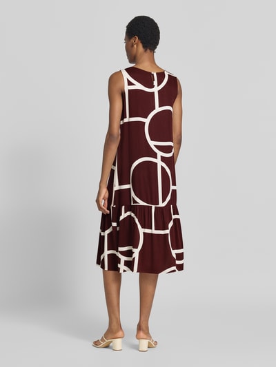 Vrouwenmodel draagt Ausgestelltes Freizeitkleid uit pure viscose model 'Wicy atelier' van OPUS in bordeauxrood met crème geometrisch patroon, vrijetijdsjurk voor dames, volledige lichaamsweergave achteraan.