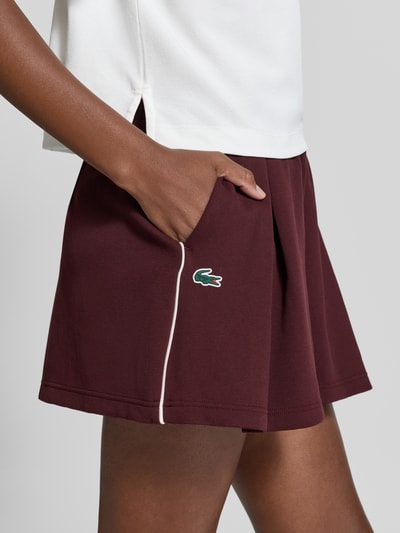 Vrouwenmodel draagt Relaxed Fit Shorts uit katoenmix van Lacoste, bordeauxrood met wit accent, Dames sweatshorts, detailopname bovenbeen