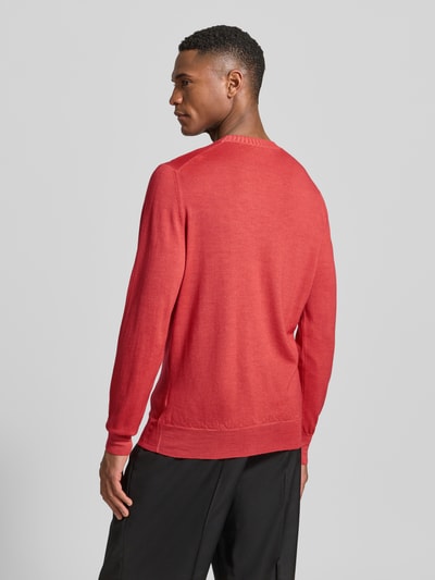 Männermodel trägt Strickpullover aus reiner Schurwolle von GRAN SASSO in Rot, körpernaher Schnitt, Rückansicht, Ganzkörperansicht.