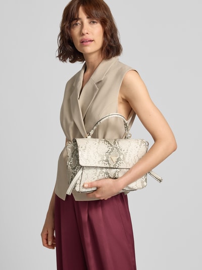 Frauenmodel trägt Shoulder Bag in Allover-Schlangen-Optik Modell 'Devon' von GUESS, dezente Beige- und Grautöne, Produktdetails sichtbar, Ganzkörperansicht von vorne.