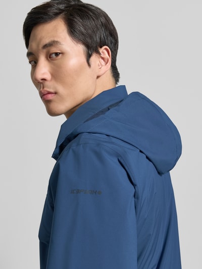 Männermodel trägt Jacke mit Kapuze Modell 'BROCTON' von Icepeak in Blau, glatte Textur, Regular-Fit, Reißverschluss, Nahaufnahme Oberkörper. Rückenlänge 65 cm, Schulterbreite 49 cm, Brustweite 57 cm, Ärmellänge 67 cm, Größe 50.