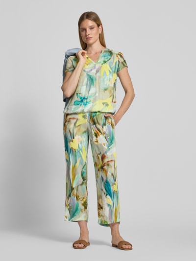 Frauenmodel trägt Stoffhose aus Viskose im Allover-Look von Betty Barclay mit farbenfrohem Muster, verkürzte Passform, Ganzkörperansicht von vorne. Damen Stoffhose, Reine Viskose, Allover-Look, Elastischer Bund, Bundweite bei Größe 36: 39 cm, Innenbeinlänge bei Größe 36: 70 cm.