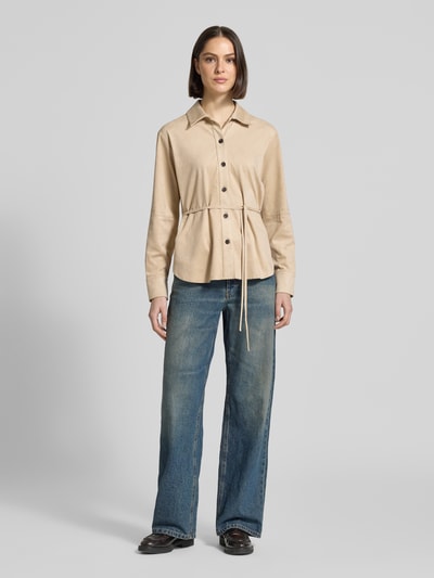 Frauenmodel trägt Bluse mit Bindegürtel Modell 'Zyla' von Someday in Beige, Hemdblusenkragen, taillierter Schnitt, Ganzkörperansicht von vorne.
