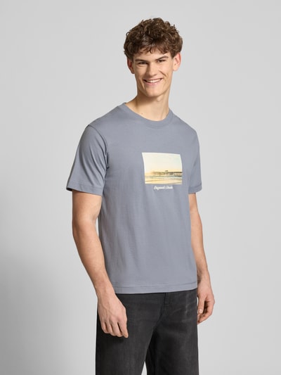 Männermodel trägt T-Shirt mit Rundhalsausschnitt Modell 'JORNORREBRO' von Jack & Jones in Grau, aus reiner Baumwolle, gerader Schnitt, Ganzkörperansicht von vorne.