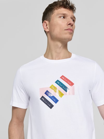 Männermodel trägt Regular Fit T-Shirt mit Label-Print von PAUL SMITH aus reiner Baumwolle, weiß mit bunten Akzenten, Nahaufnahme Oberkörper.