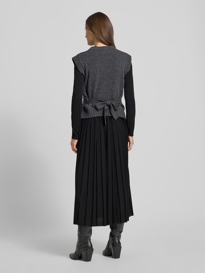 Vrouwenmodel draagt Maxi-Freizeitkleid im Set mit Strick-Pullunder aus reiner Schurwolle Modell 'EBRO' van Weekend Max Mara in effen zwart, loose fit, geplisseerd chiffon en gebreid, maxi-lengte; volledige rugaanzicht.
