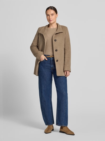 Kobiece model prezentuje kurtkę 'Jacke mit Stehkragen und Eingrifftaschen' od FUCHS SCHMITT, mieszanka materiałów z dodatkiem wełny, linia a, stójka, listwa guzikowa, wpuszczane kieszenie, długość tyłu w rozmiarze 36: 73 cm, szerokość ramion w rozmiarze 36: 37 cm, szerokość w rozmiarze 36: 48 cm, długość rękawów w rozmiarze 36: 64 cm, beżowy kolor, całościowy widok z przodu.