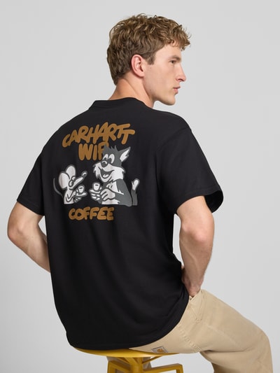 Männermodel trägt Regular Fit T-Shirt mit Motiv-Print auf der Rückseite von Carhartt Work In Progress, schwarze Baumwolle, Ganzkörperansicht Rückansicht.