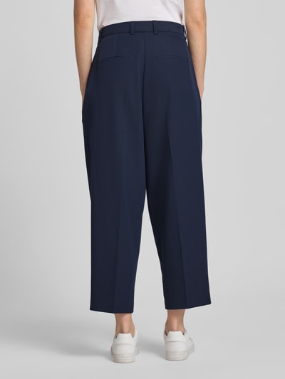 Männermodel trägt Straight Cropped Hose mit Bügelfalten von Smith and Soul, mieszanka materiałów z dodatkiem wiskozy, krój prosty, kanty, szerokość w rozmiarze S 40 cm, długość wewnętrzna nogawki w rozmiarze S 66 cm, widok całej sylwetki z tyłu.