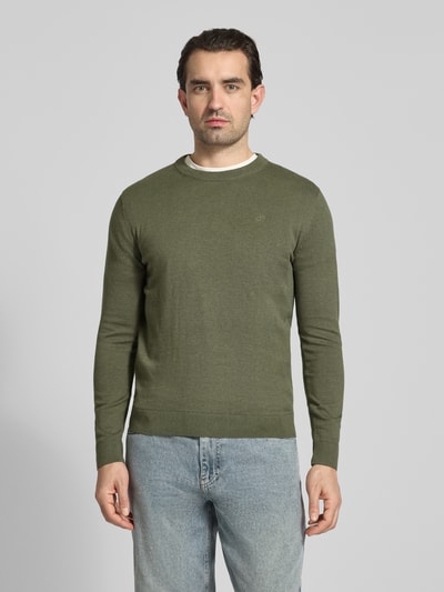 Männermodel trägt Regular Fit Strickpullover aus reiner Baumwolle von Tom Tailor in Olivgrün, unifarben, Rundhals, Rippenabschlüsse, Ganzkörperansicht von vorne.