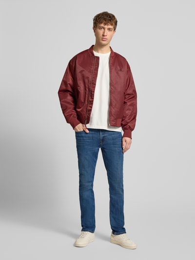 Männermodel trägt Slim Fit Jeans mit 5-Pocket-Design von Calvin Klein Jeans, Baumwoll-Mix mit Stretch-Anteil, Ganzkörperansicht von vorne.