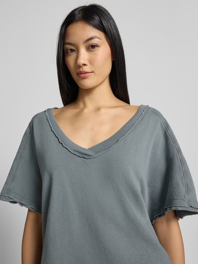 Frauenmodel trägt Sweatshirt mit 1/2-Arm von American Vintage in Grau, reine Baumwolle, gerader Schnitt, tiefer V-Ausschnitt, Nahaufnahme Oberkörper.