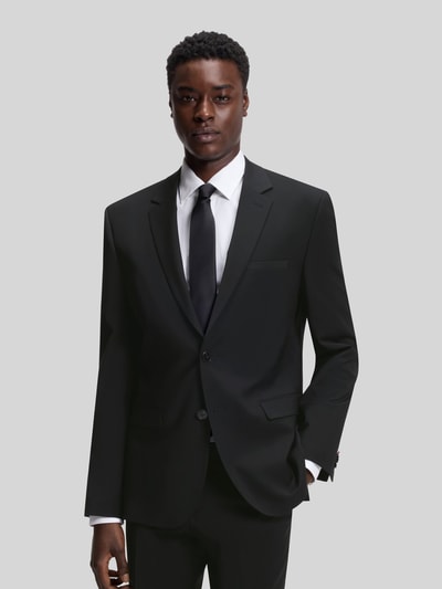 Männermodel trägt Slim Fit Anzugsakko aus Woll-Mix Modell 'ARTI' von HUGO in Schwarz mit Reverskragen, 2-Knopf-Verschluss, Ganzkörperansicht von vorne.