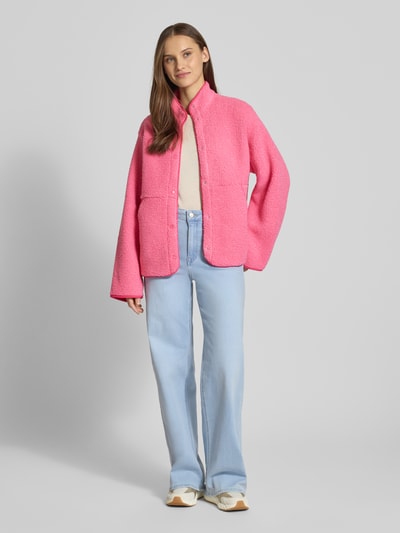 Frauenmodel trägt Relaxed Fit Fleecejacke mit Stehkragen Modell 'VERA' von JJXX aus pinkem Teddyfell, Knopfleiste, Eingrifftaschen, Rückenlänge 57 cm, Schulterbreite 41 cm, Brustweite 53 cm, Ärmellänge 54 cm, Ganzkörperansicht von vorne.