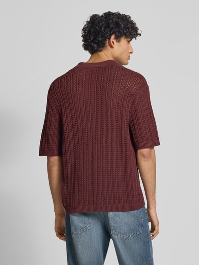 Męski model nosi Slim Fit Poloshirt in Crochet-Optik od REVIEW, bawełna, krój slim fit, bordowy, półrękaw, widok tyłem, zdjęcie całopostaciowe