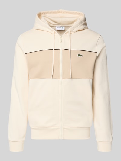 Produktfoto, Regular Fit Sweatjacke aus reiner Baumwolle von Lacoste in Creme-Beige mit Kapuze, Kontraststreifen und Logo-Patch auf glatter Sweatstruktur