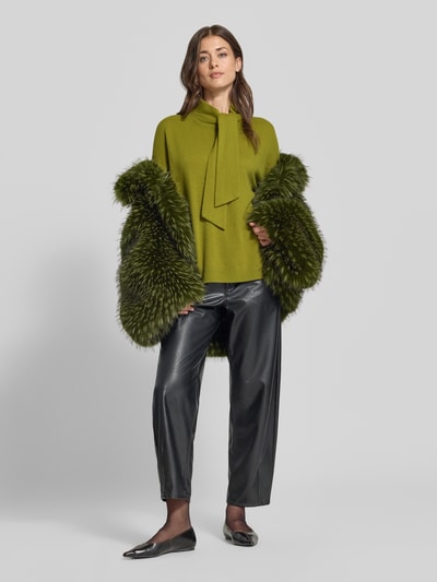 Vrouwenmodel draagt groene pullover van kasjmier met sjaal-detail van Christian Berg Woman, recht model, opstaande kraag, ribboorden, ruglengte maat M 60 cm, mouwlengte maat M 54 cm, voorkant volledig lichaam