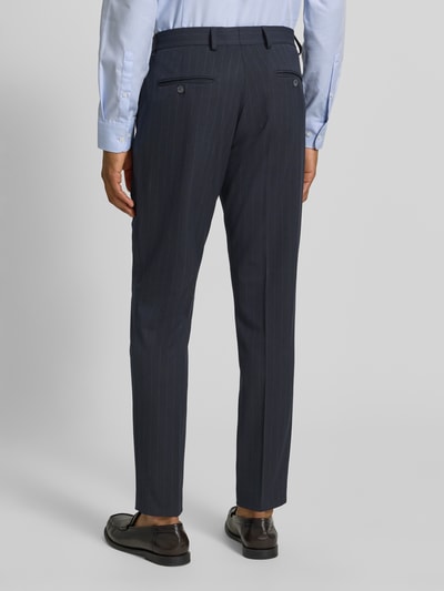 Männermodel trägt Slim Fit Anzughose mit Viskose-Anteil Modell 'PETER' von SELECTED HOMME, dunkelblau mit feinen Streifen, Ganzkörperansicht Rückansicht.