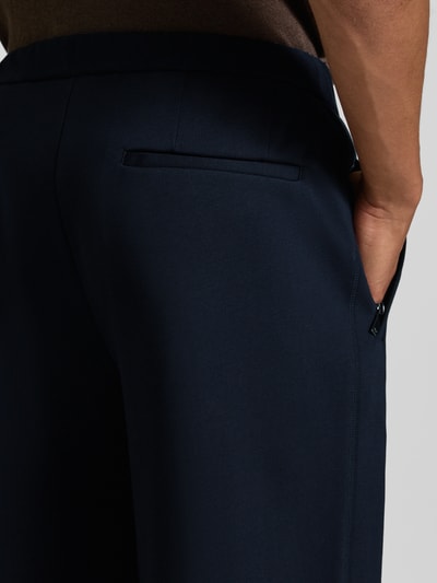 Männermodel trägt Chino mit Gesäßleistentaschen und Eingrifftaschen von Emporio Armani in Dunkelblau, Baumwoll-Mix, Detailaufnahme.