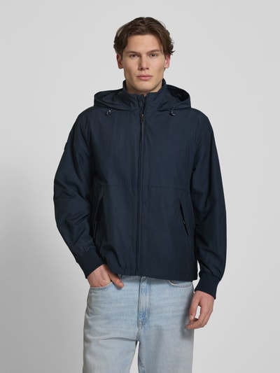 Mannenmodel draagt Jacke met opstaande kraag model 'Flyweight' van Superdry in navy, regular fit, rits, vooraanzicht bovenlichaam. Ruglengte 71 cm, schouderbreedte 45 cm, borstwijdte 53 cm, mouwlengte 66 cm.