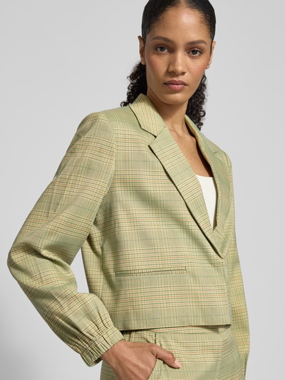 Vrouwenmodel draagt Regular fit Blazer met elastische mouwboorden Model 'Joli' van ICHI, elastische materiaalmix met viscose, reverskraag, borstzak, paspelzakken, groene ruit, modern design, halfclose up bovenlichaam.