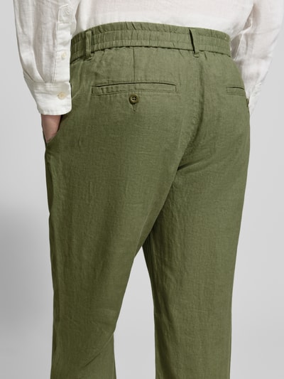 Männermodel trägt Regular Fit Leinenhose mit elastischem Bund von Gant, reine Leinen, grün, feine Struktur, Ganzkörperansicht Rückansicht. Bundweite 44 cm, Innenbeinlänge 80 cm, Schnürung.