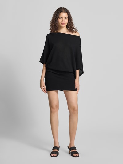 Frauenmodel trägt Minikleid mit U-Boot-Ausschnitt von Gina Tricot in Schwarz, figurbetonter Schnitt, Material-Mix mit Stretch, Ganzkörperansicht von vorne.